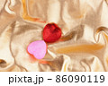 Two hearts red and pink lie on a golden background 86090119