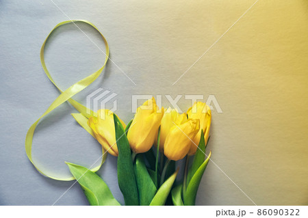 Five yellow fresh tulips on a grey background. Flowers with the number eight made of ribbon. Concept of holiday, March 8, International womans day. Horizontal card with copy space. Five yellow fresh tulips on a grey background. Flowers with the number eight made of ribbon. Concept of holiday, March 8, International womans day. Horizontal card with copy space. 86090322