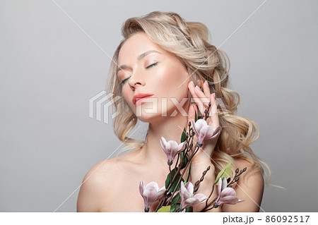 Beauty portrait of pretty woman with shiny skin touching cheek with hand on white background Beauty portrait of pretty woman with shiny skin touching cheek with hand on white background 86092517