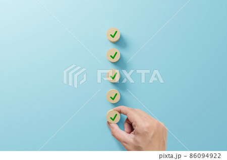 Checklist and check mark concept. Check mark on wooden blocks on light blue background 86094922