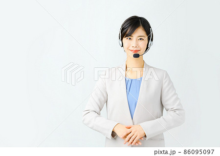 スーツ姿でヘッドセットをつけた笑顔の若い女性オペレーター スーツ姿でヘッドセットをつけた笑顔の若い女性オペレーター 86095097