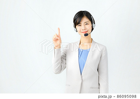 スーツ姿でヘッドセットをつけた笑顔の若い女性オペレーター スーツ姿でヘッドセットをつけた笑顔の若い女性オペレーター 86095098