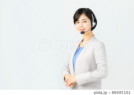 スーツ姿でヘッドセットをつけた笑顔の若い女性オペレーター 86095101
