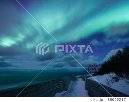 Tungeneset rocks and Aurora Borealis light. Senja islands, Norway. Stars trails and northern light. 86096217