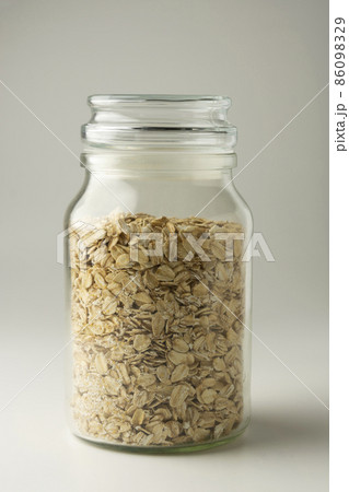 Rolled oats in glass jar on bright background 86098329