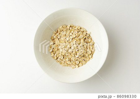 Rolled oats in a bowl on white background, top view 86098330