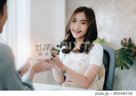 Close up of Business woman giving house after signing agreement for buying house. Bank manager and real estate concept. Close up of Business woman giving house after signing agreement for buying house. Bank manager and real estate concept. 86098556