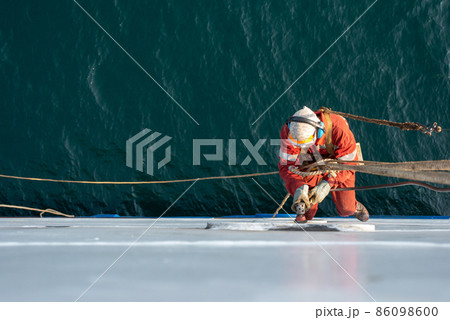 Seaman ship crew working aloft at height derusting and getting vessel ready for painting. Seaman ship crew working aloft at height derusting and getting vessel ready for painting. 86098600