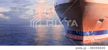 Close up of large merchant cargo ship in the middle of the ocean underway. Performing cargo export and import operations. Close up of large merchant cargo ship in the middle of the ocean underway. Performing cargo export and import operations. 86098606
