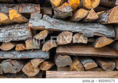 Preparation of firewood for the winter. firewood background, Stacks of firewood in the forest. Pile of firewood 86099375