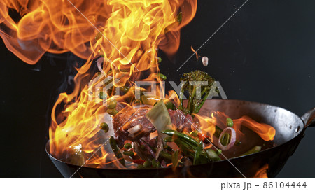 Freeze Motion of Wok Pan and Flying Ingredients in the Air. 86104444