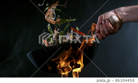 Freeze Motion of Wok Pan and Flying Ingredients in the Air. 86104458