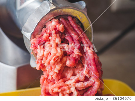 Closeup of minced meat coming out from grinder. Healthy homemade minced meat Closeup of minced meat coming out from grinder. Healthy homemade minced meat 86104676