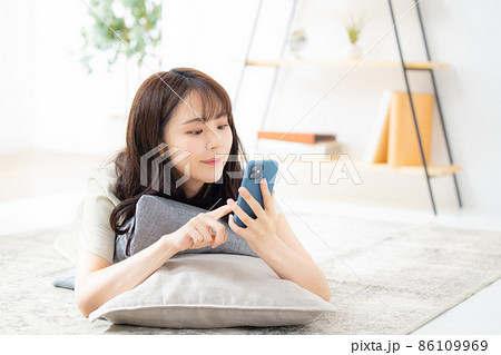 リビングでスマホを見る女性 リビングでスマホを見る女性 86109969