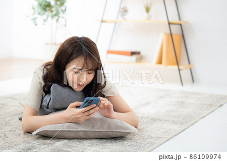 リビングでスマホを見る女性 リビングでスマホを見る女性 86109974