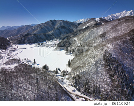 全面結氷し雪に覆われた中綱湖と爺ヶ岳　長野県大町市（ドローンによる空撮） 86110924