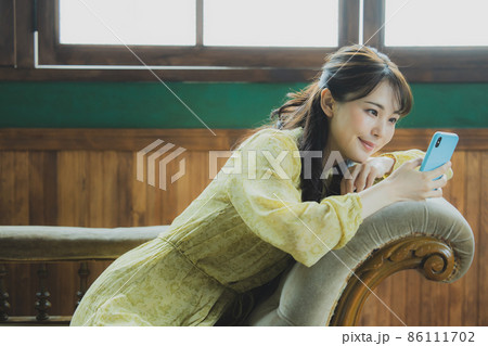 スマホを見る女性 86111702