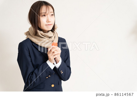 お守りを持って合格祈願をしている女子高生 86114567