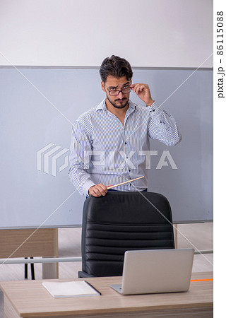 Young male teacher in the classroom 86115088