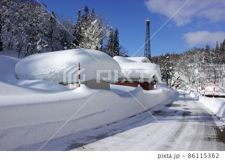 雪晴れの倉庫の雪帽子と除雪された県道 福島県只見町 雪晴れの倉庫の雪帽子と除雪された県道 福島県只見町 86115362