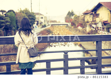 橋から川を眺める女性　bridge 86115383