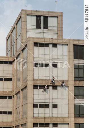 Group of workers cleaning windows service on high rise office building. Group of workers cleaning windows service on high rise office building. 86117612