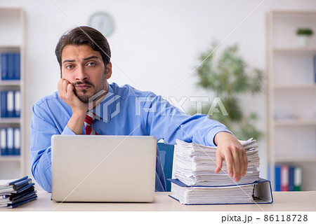 Young male employee unhappy with excessive work in the office 86118728