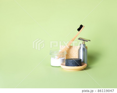 Bamboo toothbrush, steel razor and one natural soap against green background. Bamboo toothbrush, steel razor and one natural soap against green background. 86119047