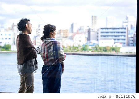 ベランダから外を眺める男女 86121976