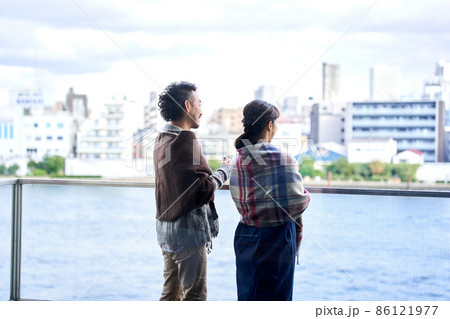 ベランダから外を眺める男女 86121977