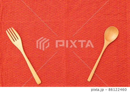 赤色のランチョンマットと木製のスプーンとフォーク 86122460