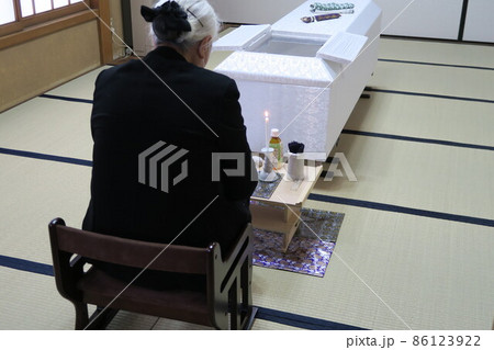 お線香を手向ける親族 86123922