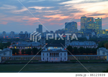 イギリスロンドン 世界遺産マリタイムグリニッジの旧王立海軍学校と夕焼けのビル群の写真素材