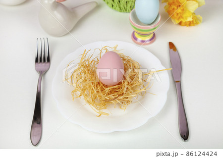 Easter table setting and dinner with multicolored eggs. Easter table setting and dinner with multicolored eggs. 86124424