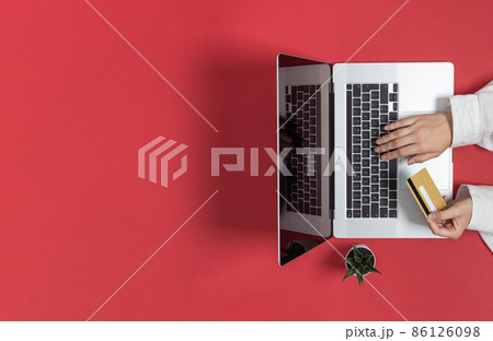 Person hands using credit card for online shopping or banking top view on red background. Person hands using credit card for online shopping or banking top view on red background. 86126098