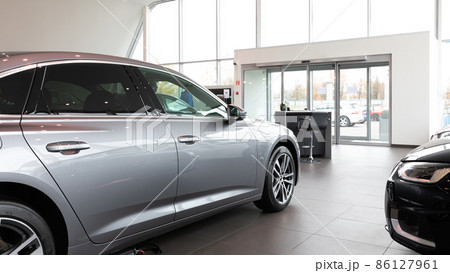Premium car dealership entrance with gray car in the foreground 86127961
