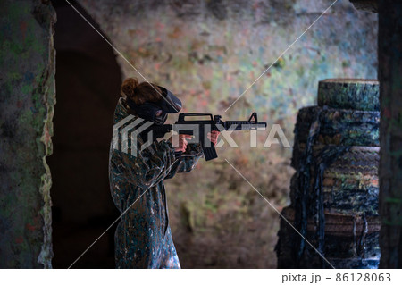 young woman in action while playing paintball 86128063