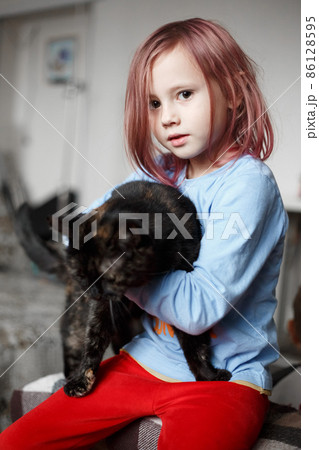 Portrait of adorable caucasian girl holding cute black cat. Portrait of adorable caucasian girl holding cute black cat. 86128595
