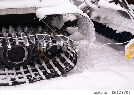 Metal tracks of a snowplow car in winter in the snow Metal tracks of a snowplow car in winter in the snow 86128702