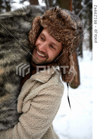 Men playing with siberian husky in winter forest and park, animals and ecology. Pet lover. Dog - human s friend concept Men playing with siberian husky in winter forest and park, animals and ecology. Pet lover. Dog - human s friend concept 86129942