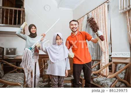 Excited asian father, mother and daughter holding cleaning tools 86129975