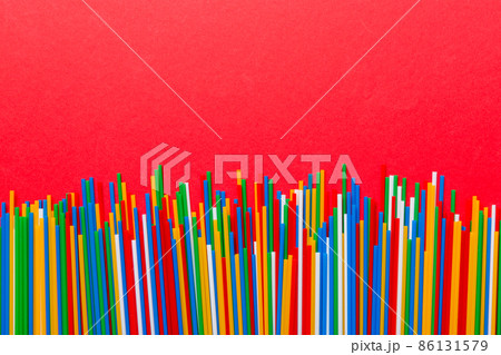Heap of colorful plastic drinking straws on Colored background, flat lay. Copy Space for text Heap of colorful plastic drinking straws on Colored background, flat lay. Copy Space for text 86131579