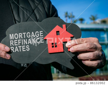 Man shows inscription Mortgage refinance rates and home. Man shows inscription Mortgage refinance rates and home. 86132002