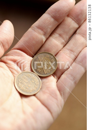 古い十円玉を持つ手　二十円を持っている左手 86132138