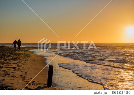 Den Helder, Netherlands. January 2022. Setting sun on the beach of Den Helder, Netherlands. Den Helder, Netherlands. January 2022. Setting sun on the beach of Den Helder, Netherlands. 86133486
