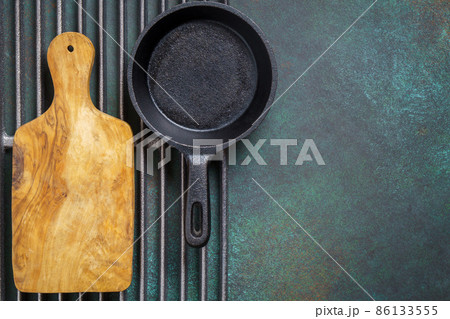 Cast iron pan and cutting board on grill grate Cast iron pan and cutting board on grill grate 86133555