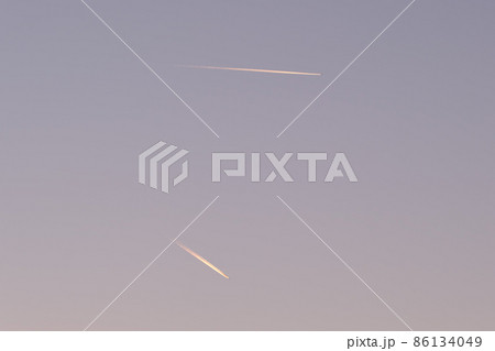 Distant passenger jet plane flying on high altitude on clear blue sky leaving white smoke trace of contrail behind. Air transportation concept 86134049