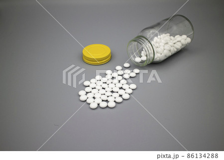 薬瓶からこぼれた白い錠剤/グレー背景 White tablets on gray paper 薬瓶からこぼれた白い錠剤/グレー背景 White tablets on gray paper 86134288
