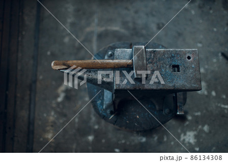 Blacksmith's hammer on metal anvil at forge. Overhead view 86134308