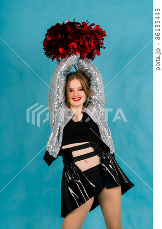 Young lady cheerleader posing in the studio, isolated on red and blue 86135443